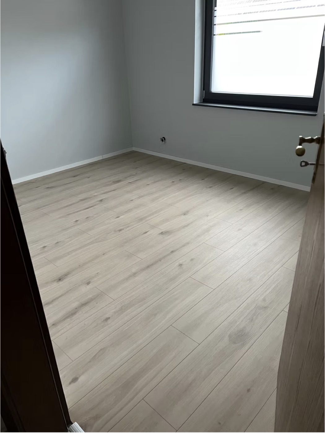 Neu verlegter heller Laminatboden in einem renovierten Zimmer